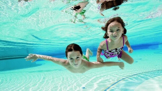 Una piscina al aire libre de temporada, sombrillas