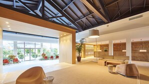 A spacious lobby with a modern design, featuring a large seating area, a reception desk, and a view of the outdoors. - Prinsotel La Dorada (Muro)