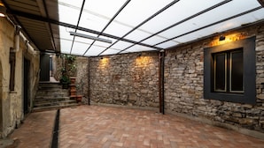 A courtyard with stone walls, a brick floor, and a glass ceiling structure. - In Riva al Lago (Como)