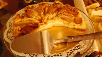 A pizza on a plate with a metal spatula.