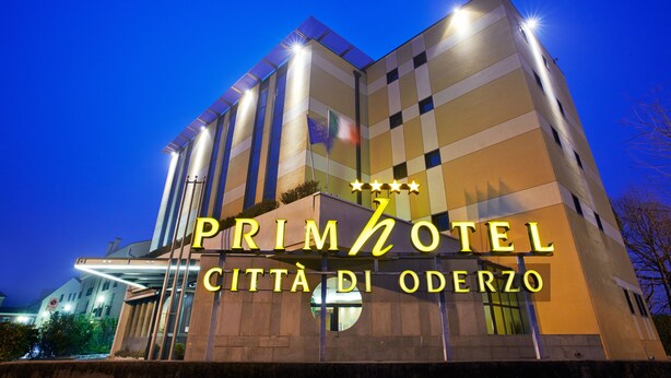A hotel with a modern design, featuring a prominent sign with the name "PRIMHOTEL CITTÀ DI ODERZO" and three stars. - Primhotel (Oderzo)