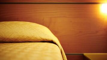 Ein Bett mit einer gewebten Decke und einem Holzkopfteil.