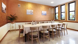 A conference room with a long table, chairs, and a potted plant. - Primhotel (Oderzo)