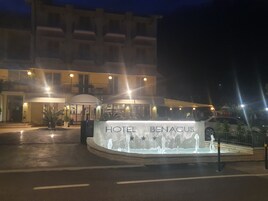 A hotel entrance with a fountain and the name 'HOTEL BENACUS' visible.