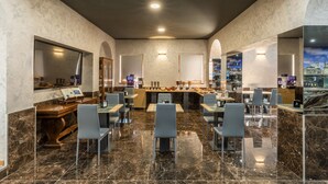 Un restaurante moderno con suelo de mármol, una barra central y diversas opciones de asientos.