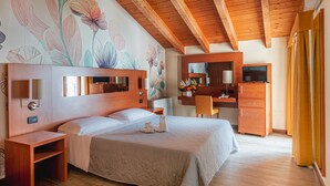 Un dormitorio con cama, mesita de noche, cómoda y espejo.