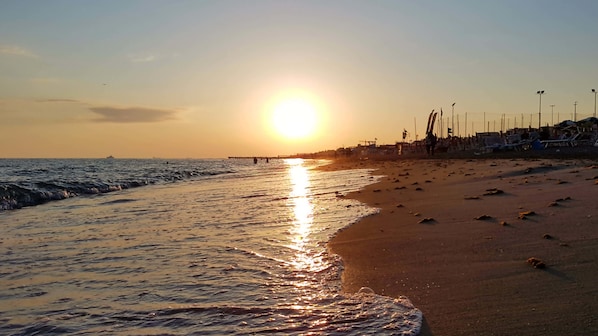 Una spiaggia nelle vicinanze, sabbia scura, teli da spiaggia