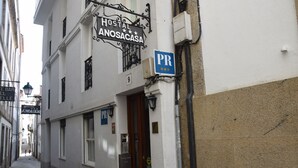 A narrow street with a hostel named 'Hostal Anosacasa' and a parking sign. - Hostal Anosa Casa (Santiago de Compostela)