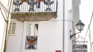 A white building with a balcony, a door, and a sign for 'Hostal Anosacasa'. - Hostal Anosa Casa (Santiago de Compostela)