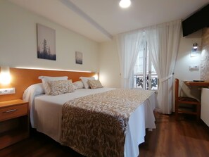 A hotel room with a bed, bedside tables, a desk, and a window with curtains. - Hostal Anosa Casa (Santiago de Compostela)