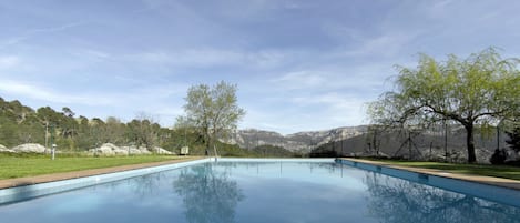 Una piscina al aire libre, sombrillas, tumbonas