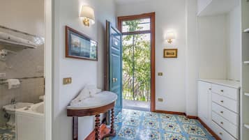 A bathroom with a sink, mirror, and a door leading to a balcony.