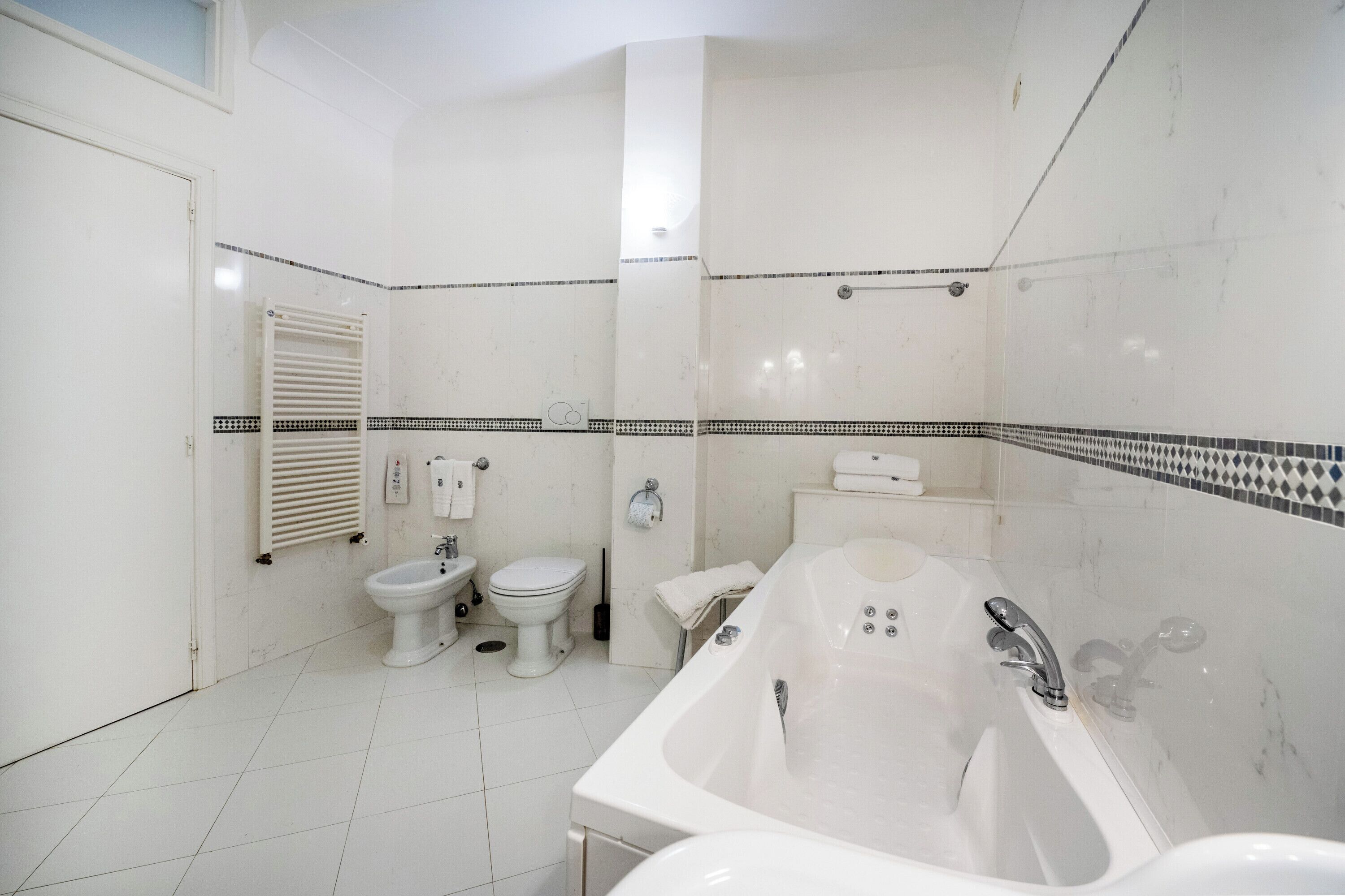 A bathroom with a bathtub, toilet, and bidet.