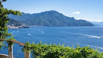 A coastal view with a mountain backdrop, a clear sky, and a body of water.