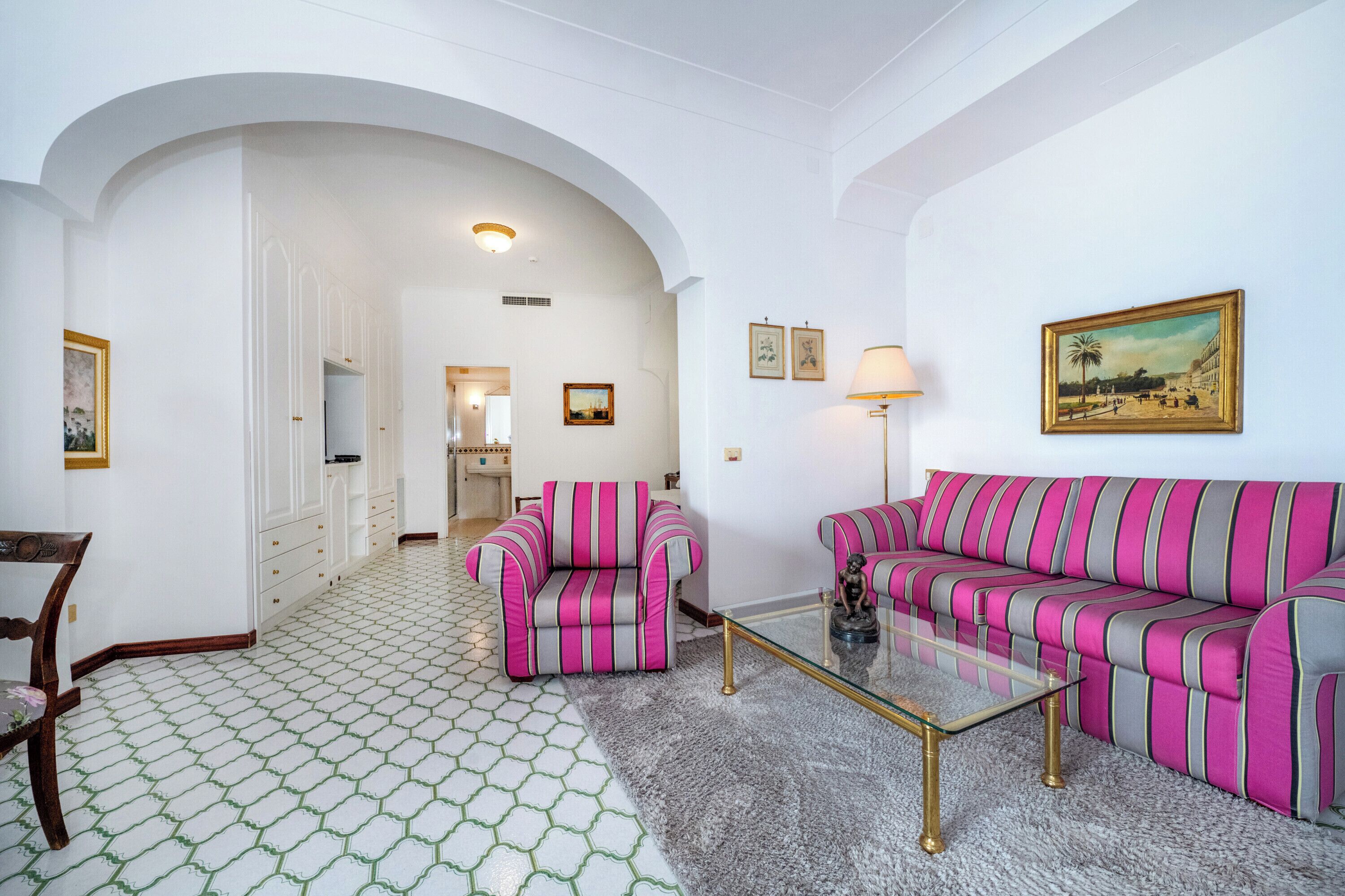 A living room with a sofa, armchairs, and a coffee table.
