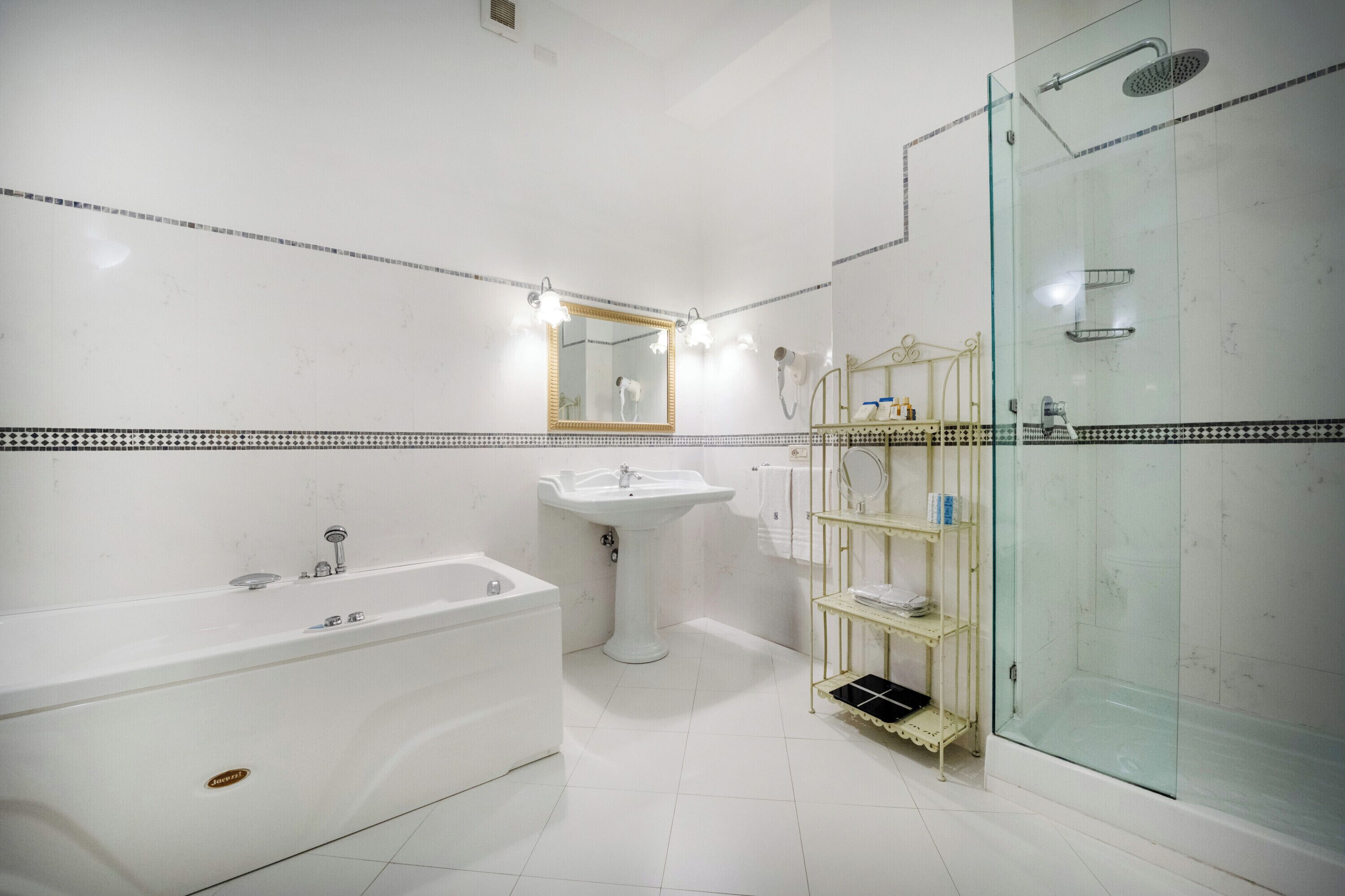 A modern bathroom with a bathtub, sink, and glass-enclosed shower.