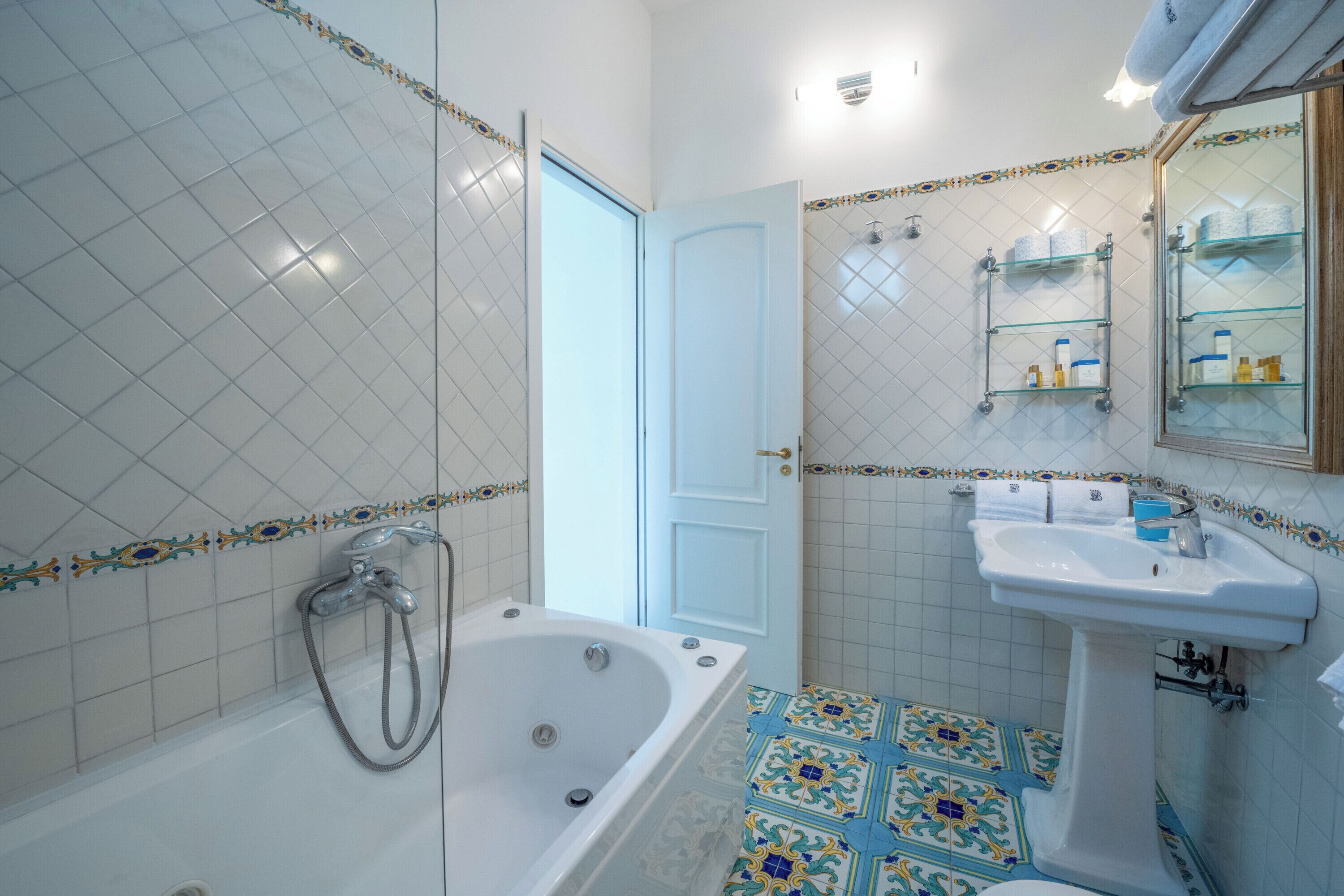 A bathroom with a bathtub, sink, and tiled floor.