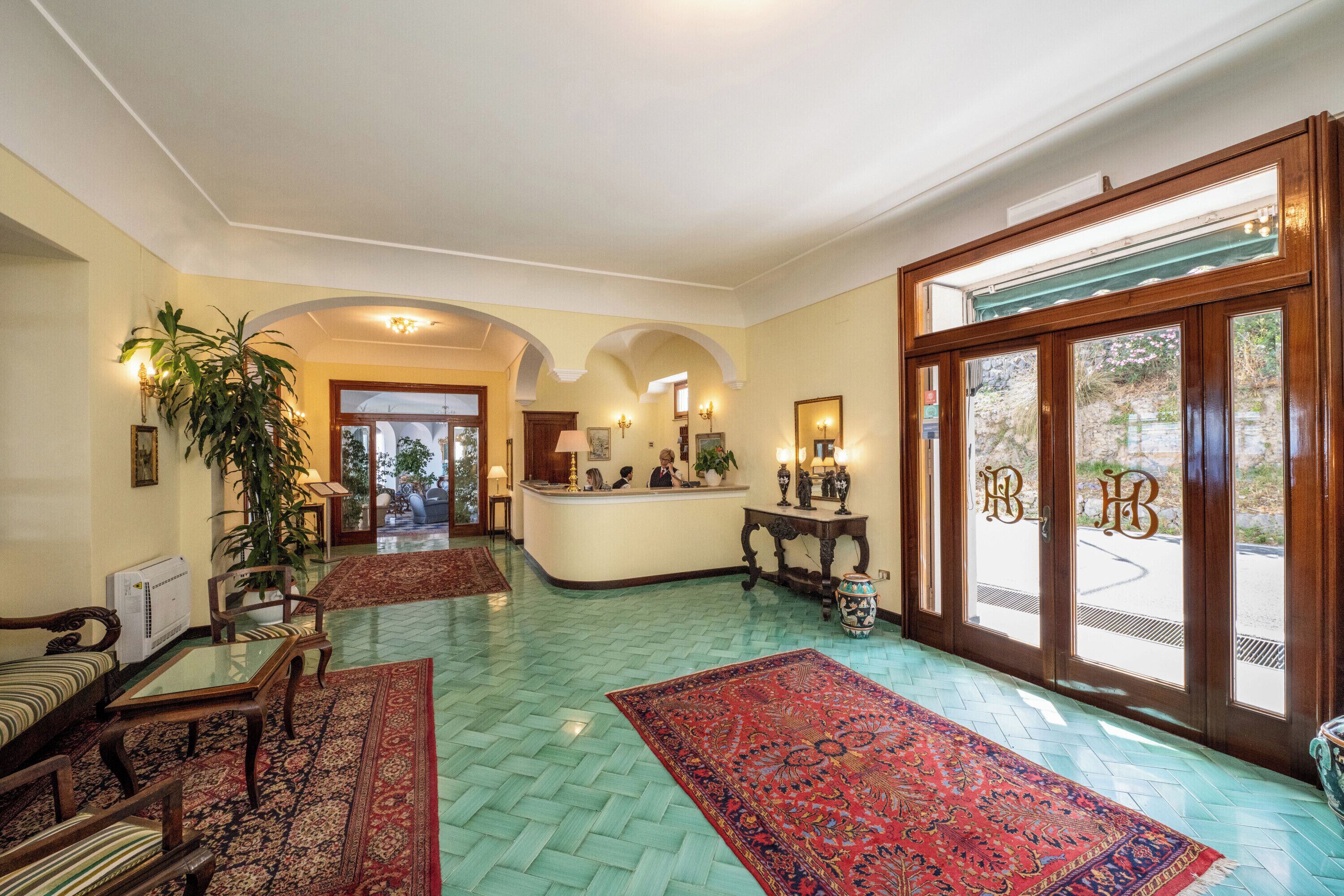 A lobby with a reception desk, seating area, and a large window with a view.