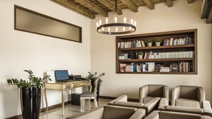 Una sala de estar moderna con una estantería, sofás de cuero, un escritorio con una computadora y una planta grande en maceta.
