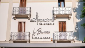 Un edificio con un letrero que dice 'alla veneziana ristorante La Braserle pizza & food'.