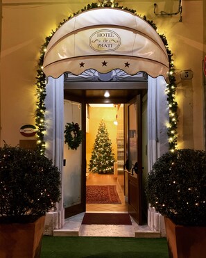 A hotel entrance with a Christmas tree, a sign reading "HOTEL de PRATI", and a number "5" on the wall. - Hotel De Prati (Ferrara)