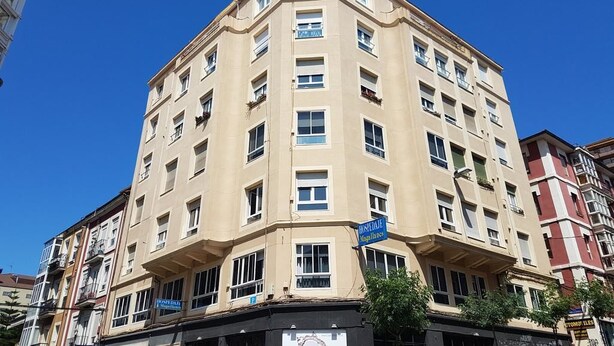 A multi-story building with a beige facade, multiple windows, and balconies. - Hospedaje Magallanes (Santander)
