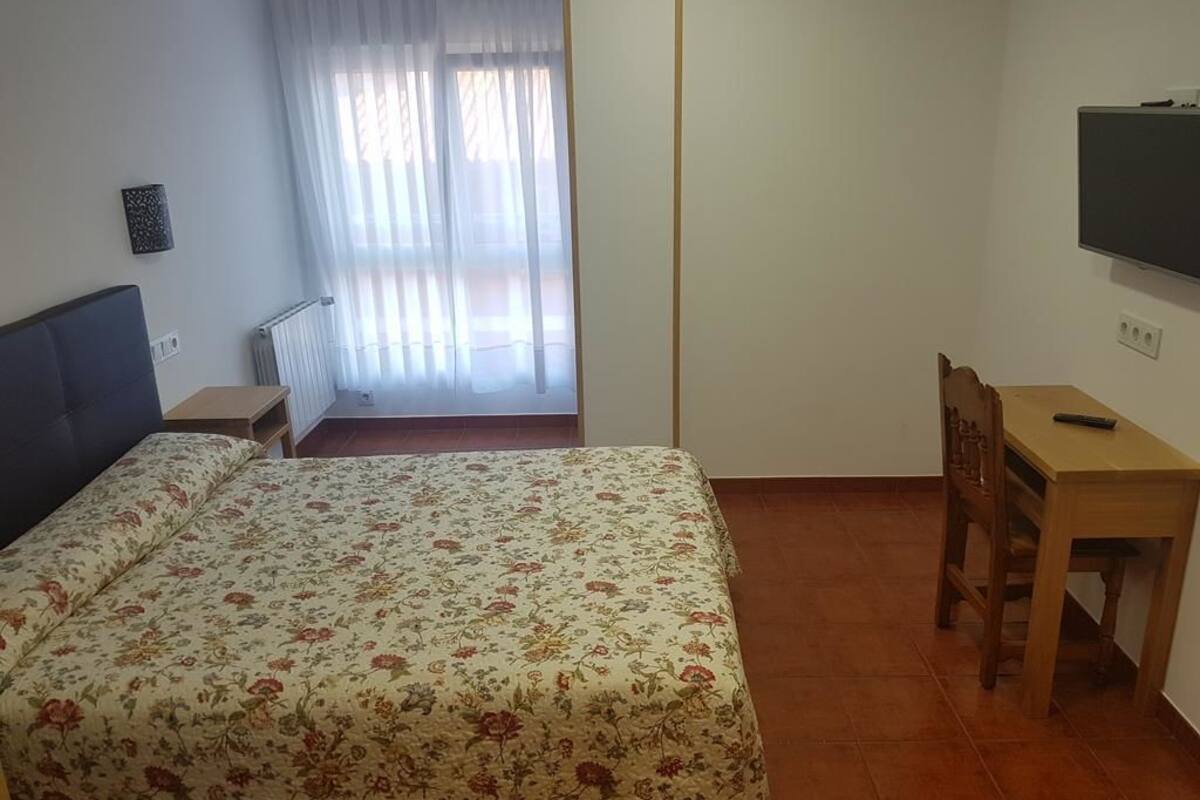 Une chambre à coucher avec un lit, un bureau et une chaise.