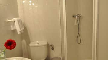 Un baño con inodoro, bidé, lavabo y ducha.
