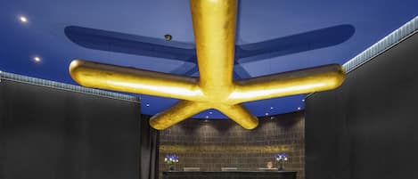 Un espace d’accueil au design moderne, doté d’une structure de plafond originale et d’un comptoir de réception.