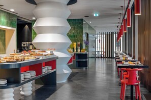 A modern dining area with a central buffet and long tables with red chairs. - Hotel Glam Milano (Milan)
