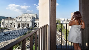 A balcony with a view of a historic building and a busy street. - Hotel Glam Milano (Milan)