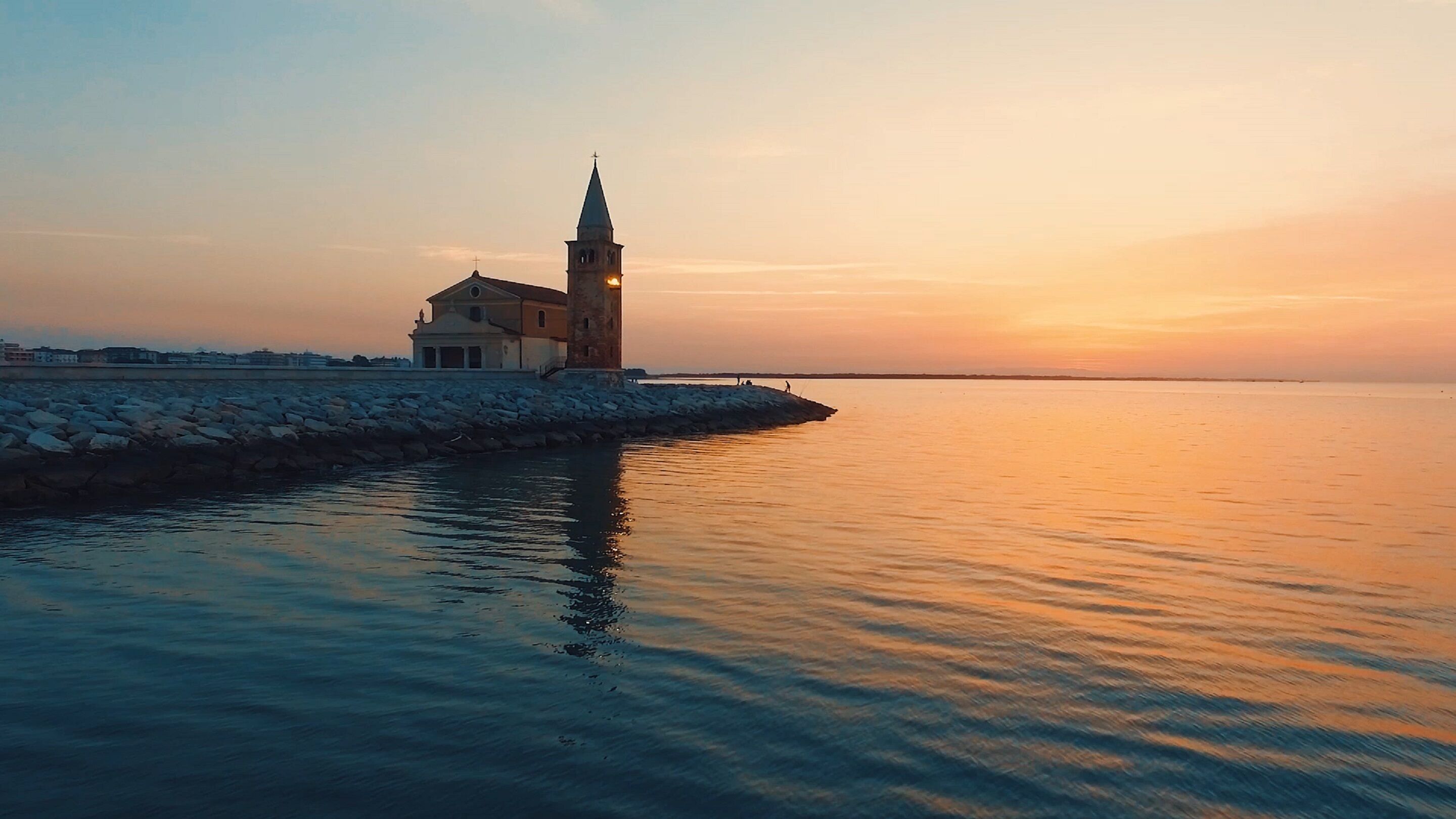 A coastal building with a tower, situated by the water.