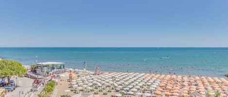 Na praia, espreguiçadeiras, toalhas de praia, prática de ioga na praia 