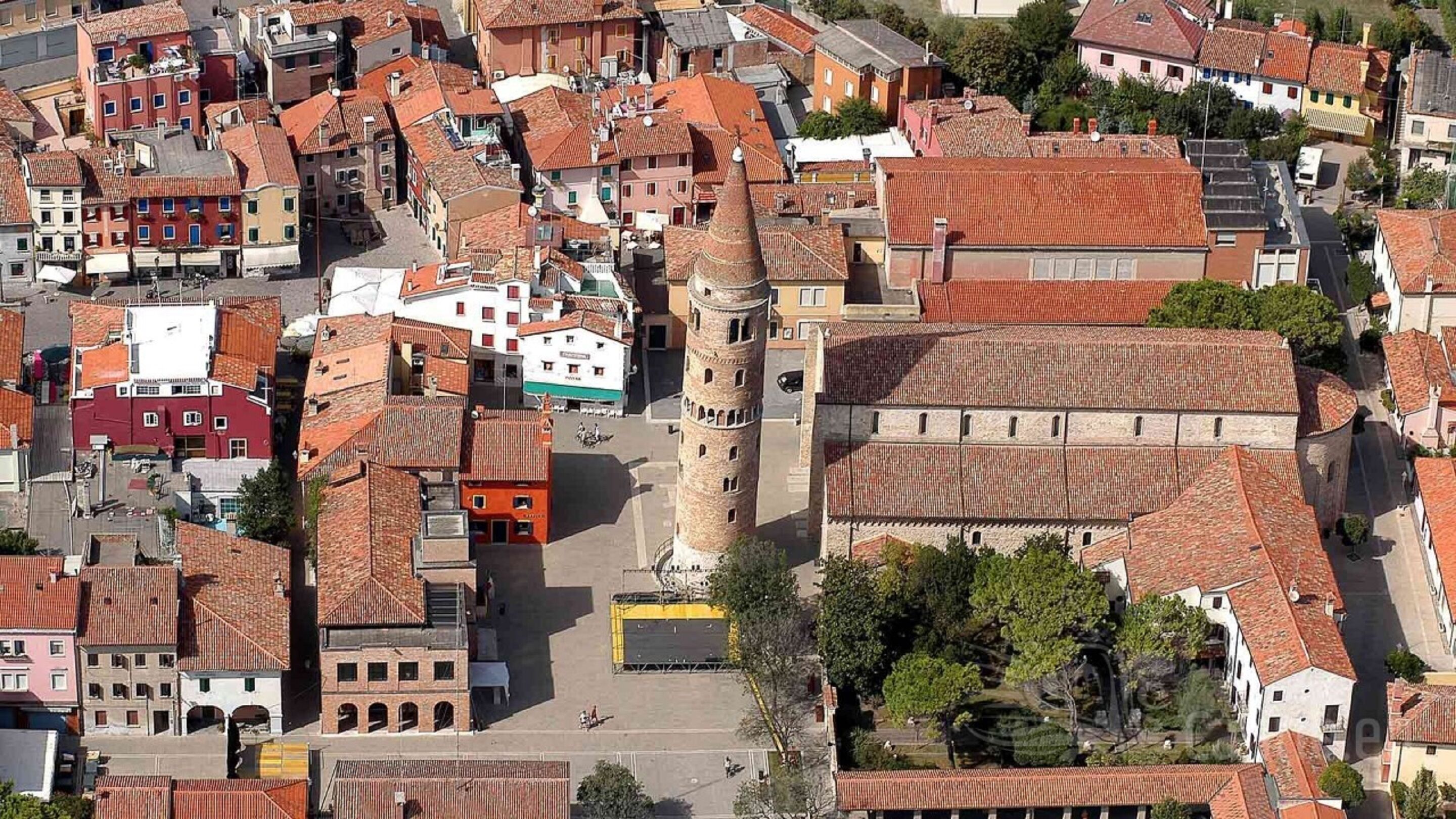An aerial view of a historic town with narrow streets, traditional buildings, and a prominent tower.