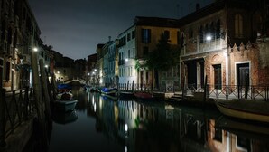 A canal with boats, historic buildings, and a bridge. - Hotel Austria (Caorle)