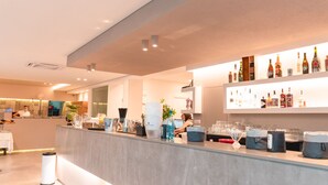 A modern bar area with a counter, bar tools, and a variety of bottles and glasses. - Valle Verde (Grammichele)