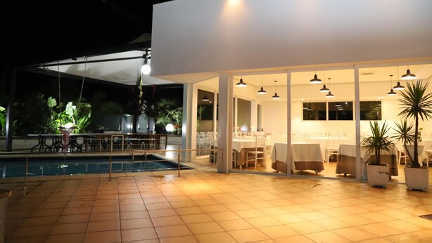 An outdoor dining area with a pool, covered seating, and potted plants. - Valle Verde (Grammichele)