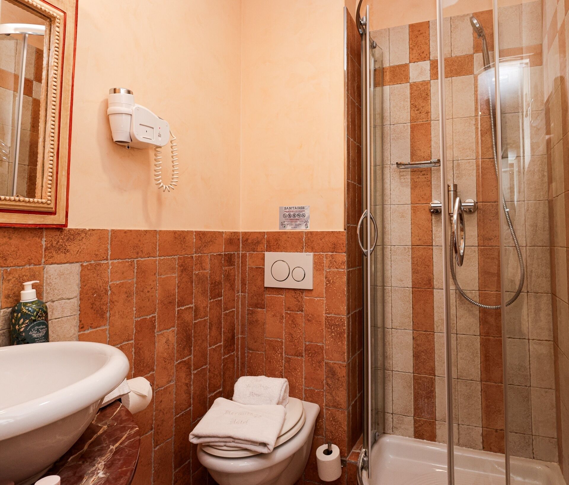 Une salle de bain avec un lavabo, des toilettes et une douche.