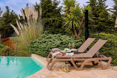 Una piscina al aire libre de temporada, sombrillas