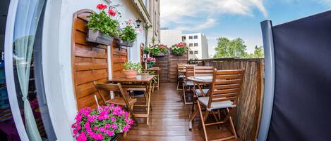 A wooden deck with outdoor furniture and potted plants.