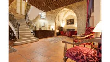 A spacious lobby with a grand staircase, a fireplace, and comfortable seating areas.