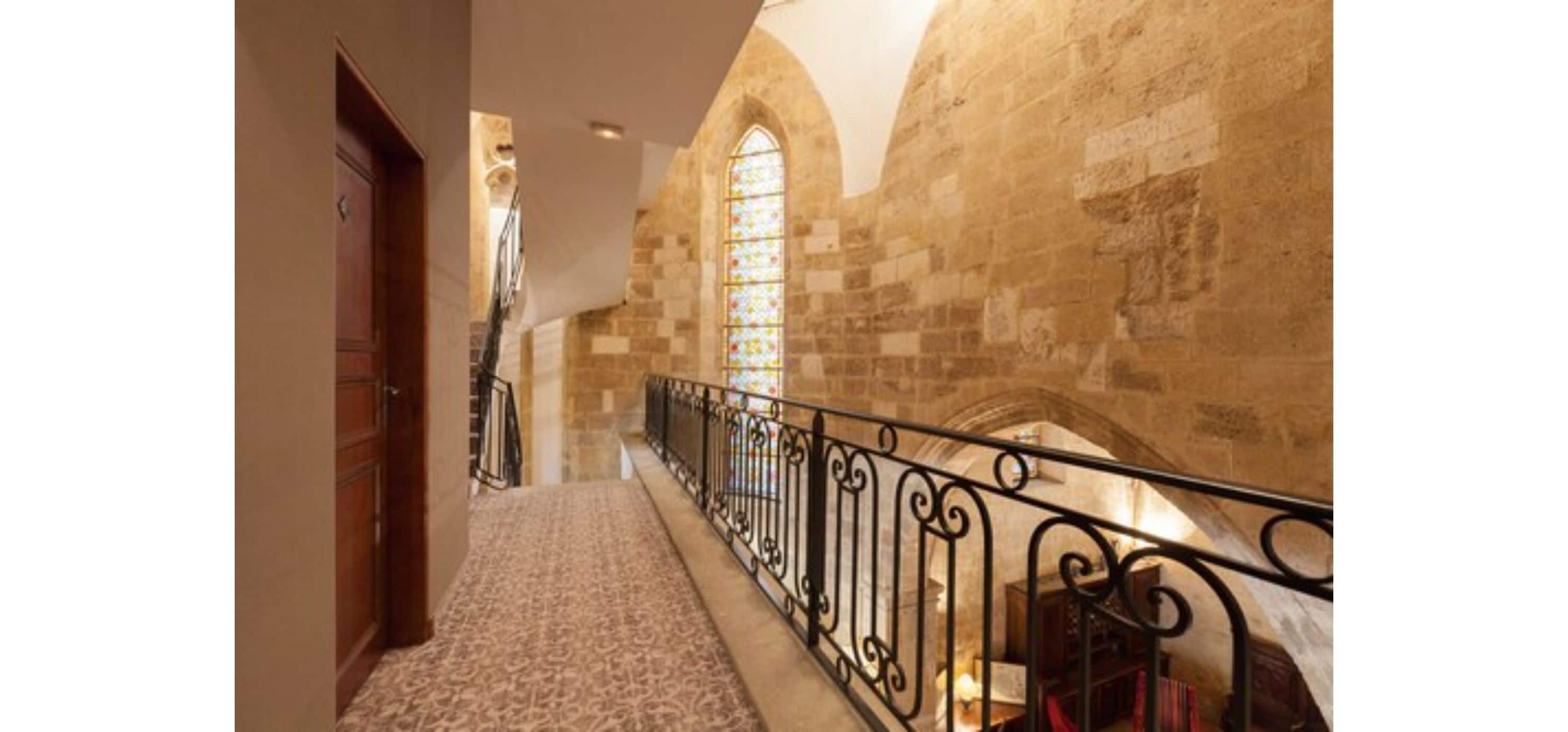 A stone staircase with a wrought iron railing leading to a landing.