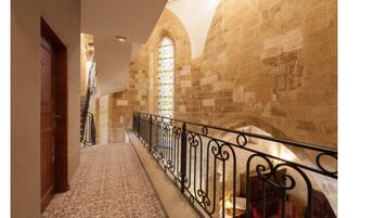 A stone staircase with a wrought iron railing leading to a landing.