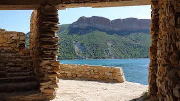 Una construcción de piedra con vista a un lago y montañas.