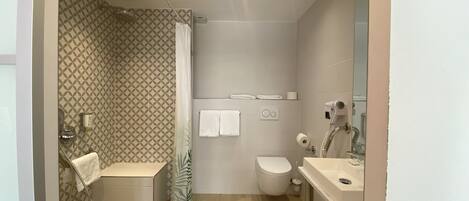 A modern bathroom with a shower, toilet, and sink.