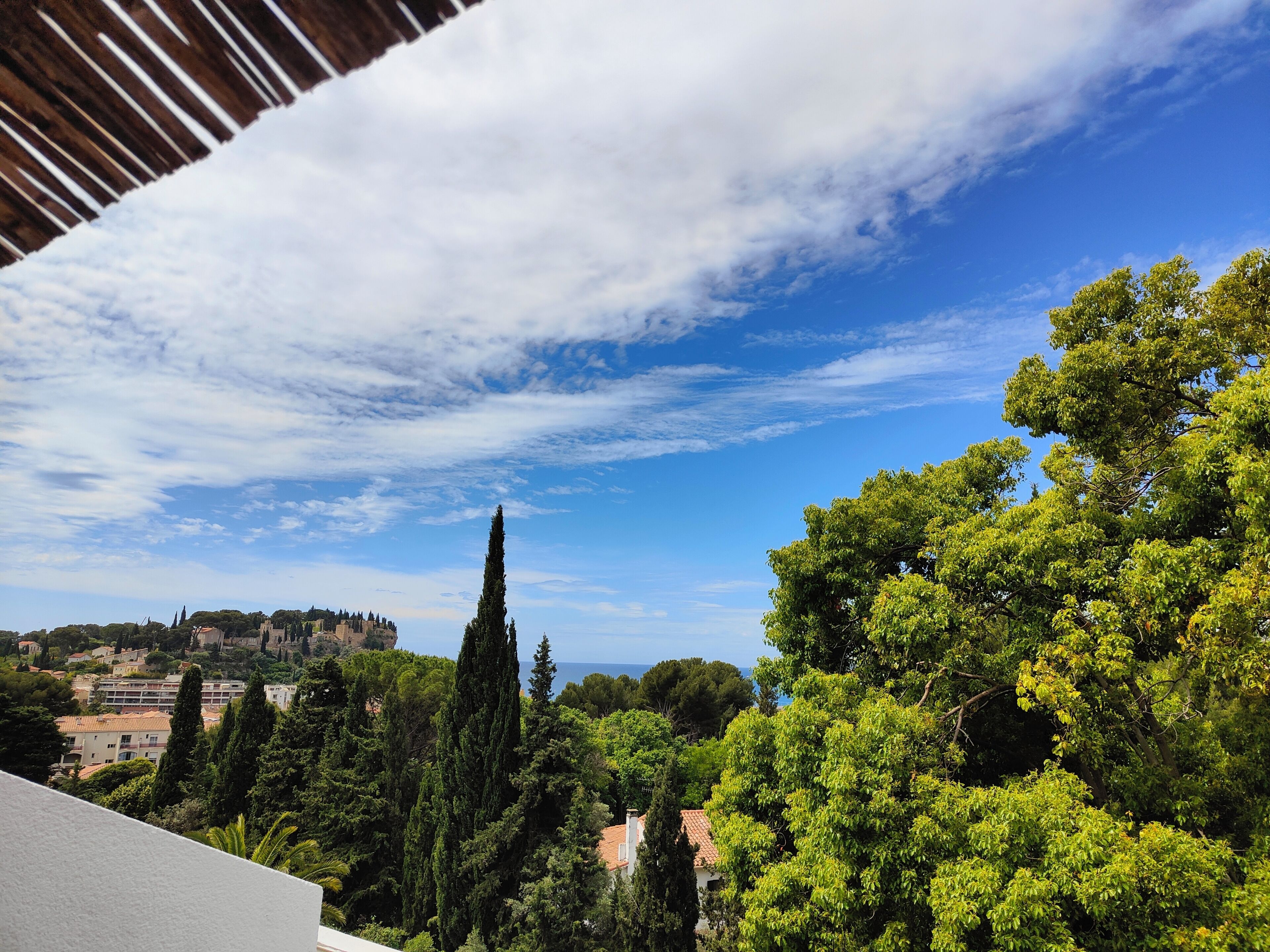 Vista de un pueblo con edificios, árboles y cielo despejado.