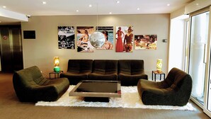 Un hall d’entrée moderne avec un ensemble de canapés, une table basse et des œuvres d’art murales.