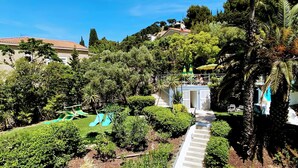 Un complexe hôtelier doté d’une piscine, de chaises longues et d’un escalier menant à un bâtiment.