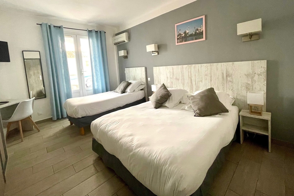 Ein Hotelzimmer mit zwei Betten, einem Schreibtisch und einem Stuhl.