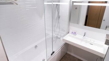A modern bathroom with a glass-enclosed shower, a white sink, and a mirror above the sink.